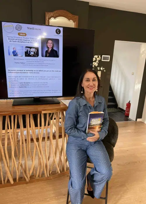 Femme tenant un livre devant un écran